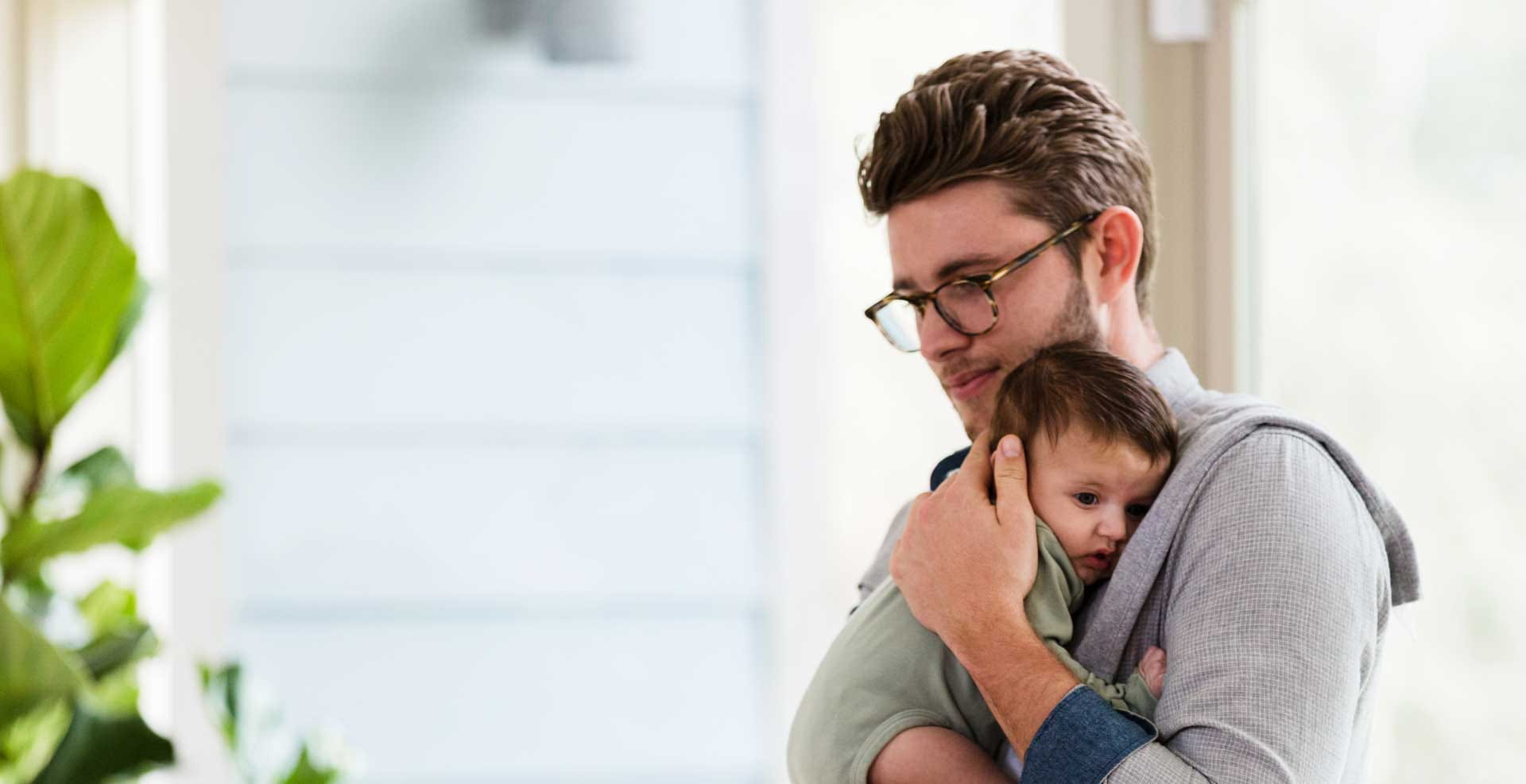 A despondent father holds his newborn baby